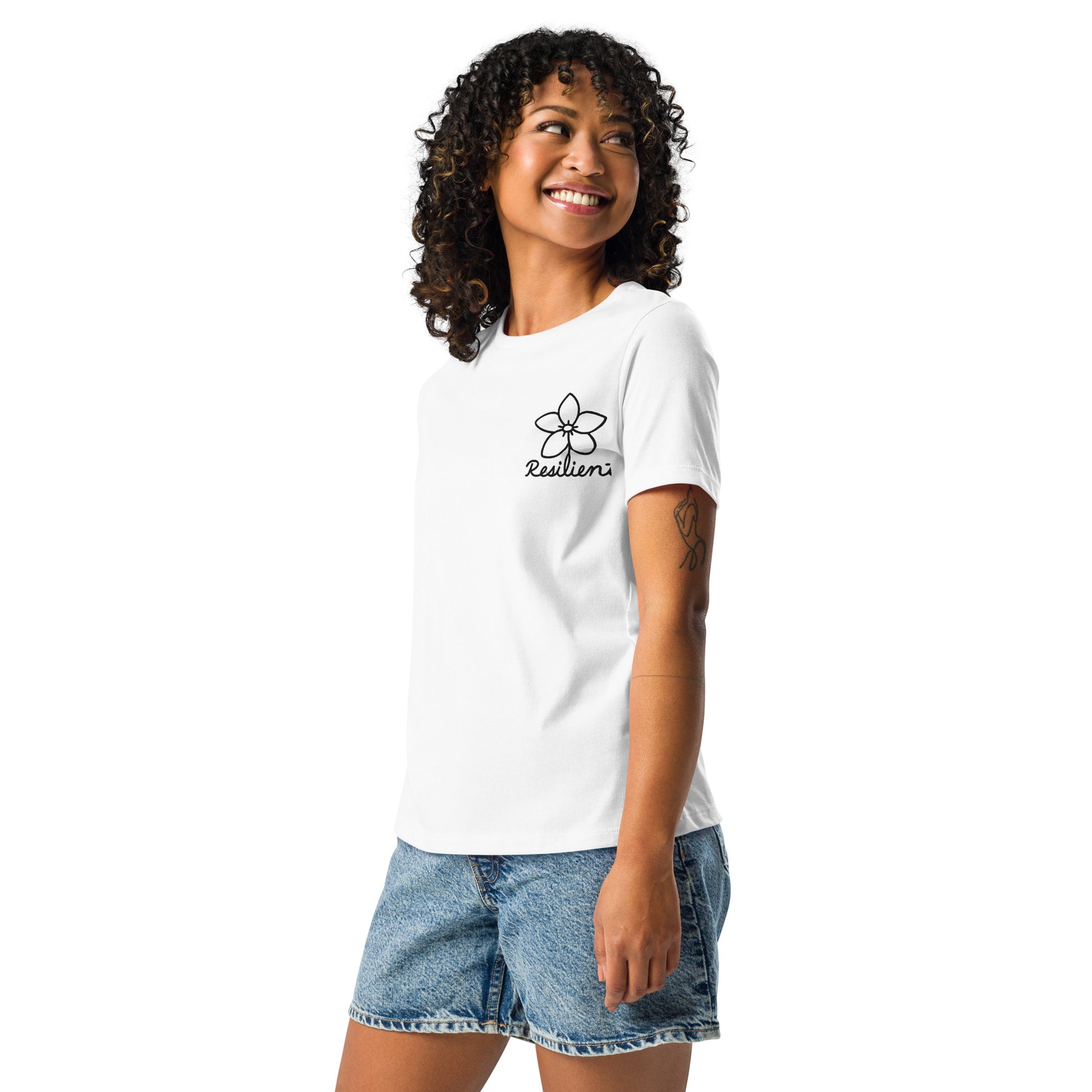 Woman in white EverHardy short-sleeve t-shirt, side view, looking over shoulder and smiling.